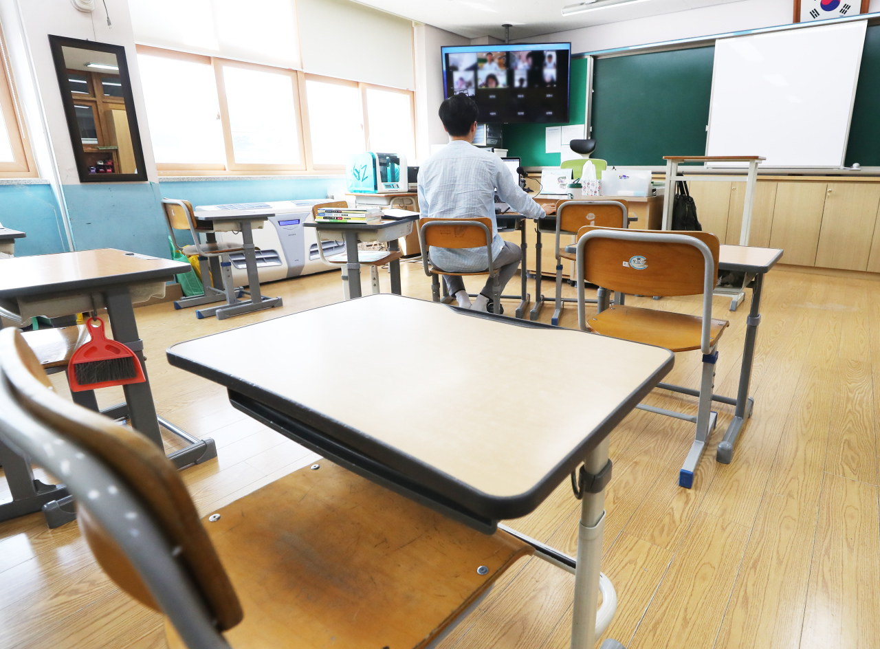 A teacher runs an online class Wednesday in an empty classroom of the Hanter Elementary School in Yongin, Gyeonggi Province. (Yonhap)