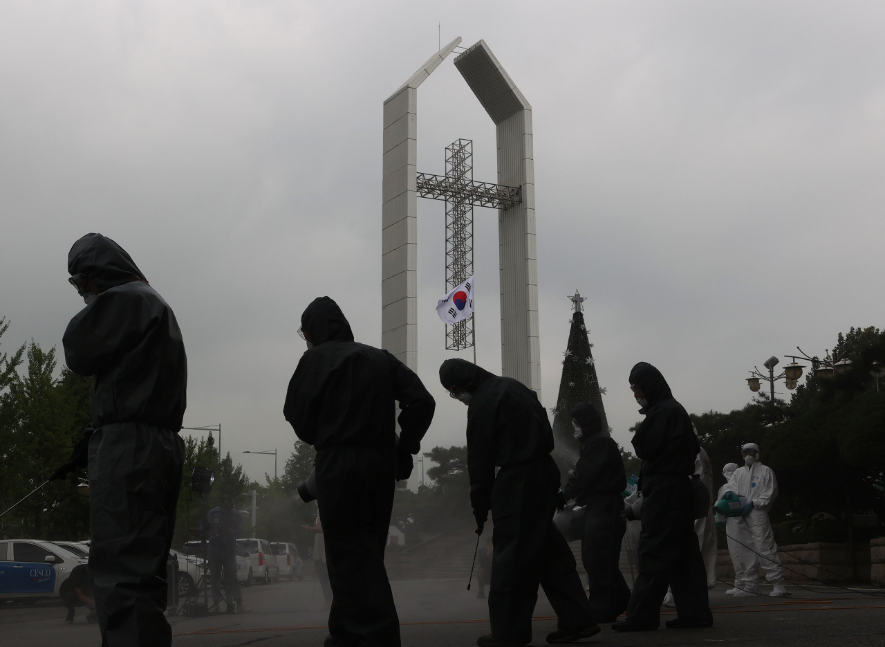 Disease control officials are engaged in sanitary efforts Tuesday at the Yeouido Full Gospel Church in western Seoul. South Korea has been fighting after a large cluster of infections traced to Protestant churchgoers was discovered. (Yonhap)