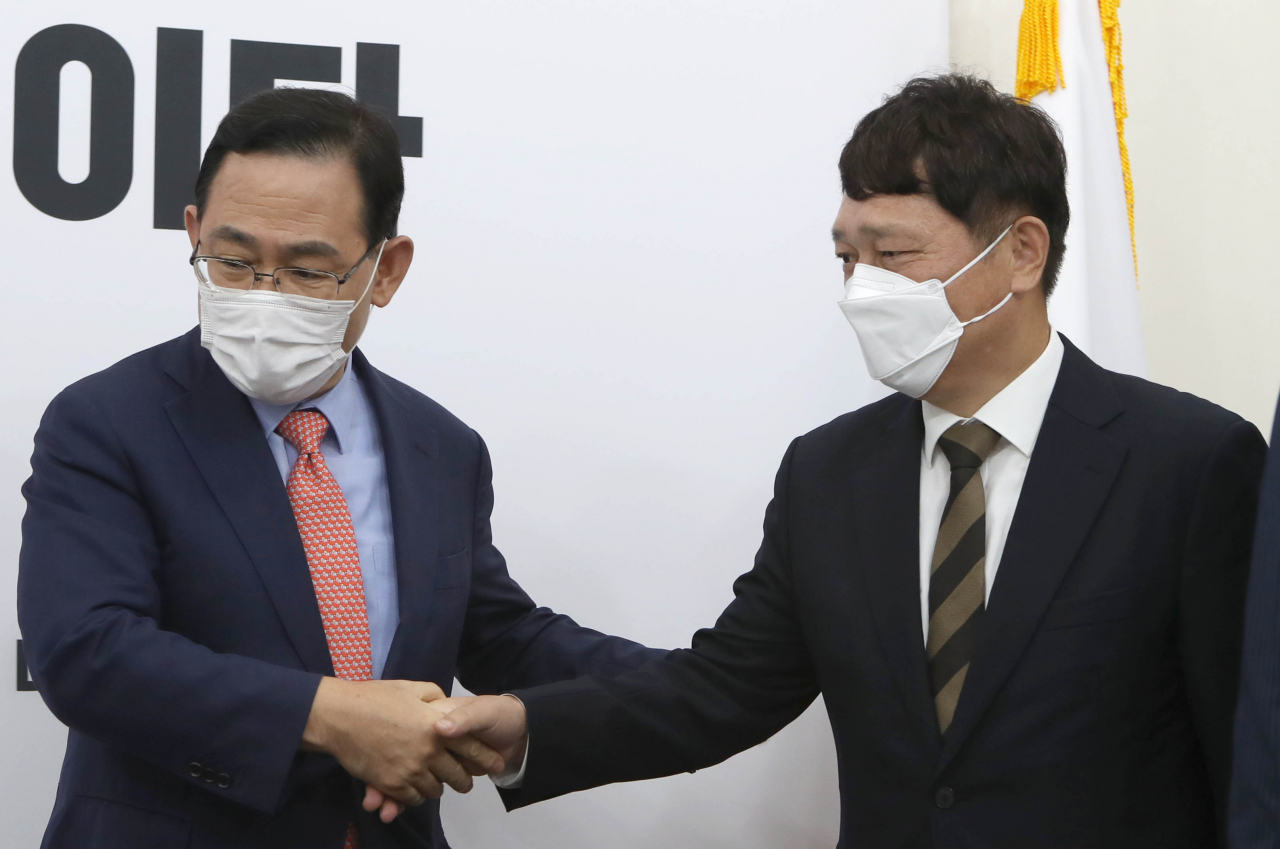 주호영 미래통합당 원내대표(왼쪽)가 20일 국회 원내대표실에서 최재성 청와대 정무수석와 악수하고 있다. [연합]