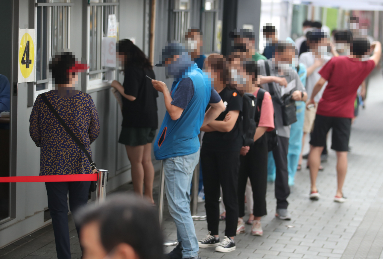 21일 오전 서울 성북구보건소에 마련된 신종 코로나바이러스 감염증(코로나19) 선별진료소를 찾은 시민들이 검사받기 위해 줄을 서고 있다. [연합]