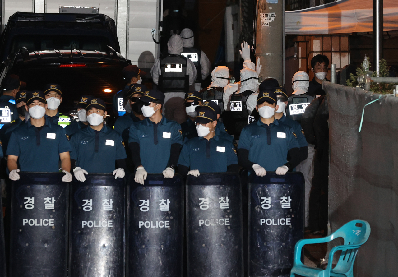 Police officers wearing protective gear enters Sarang Jeil Church in Seoul on Friday for a search and seizure operation. (Yonhap)