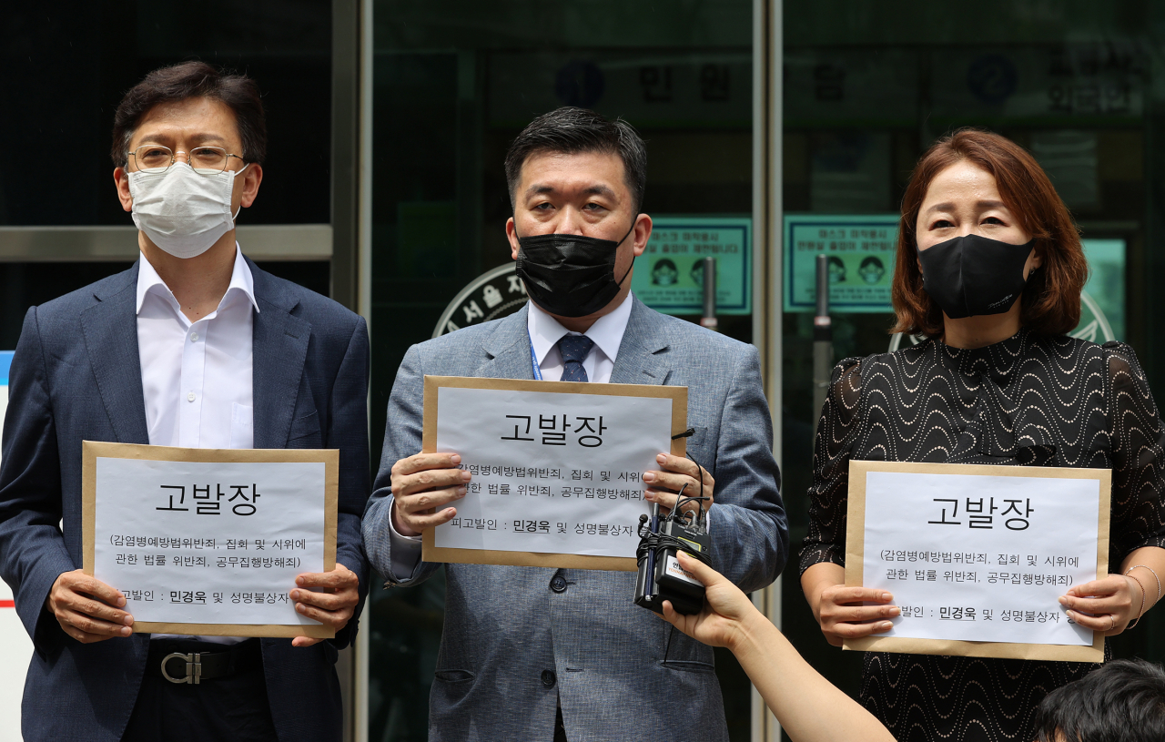 이재정 더불어민주당 의원(오른쪽부터), 최현 박주민 당대표 선거대책본부 기획상황실장, 현근택 대변인 등이 21일 오후 서울 종로구 서울지방경찰청 앞에서 광복절 집회와 관련해 민경욱 전 의원 등을 감염병예방법 위반 혐의 등으로 고발한다고 밝히고 있다. [연합]