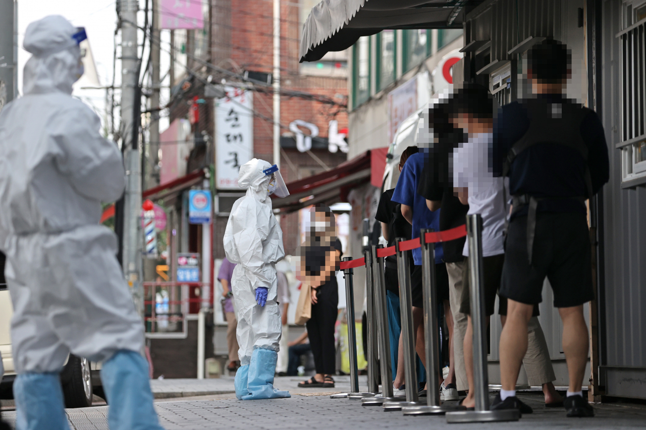 지난 23일 오전 서울 성북구보건소에 마련된 선별진료소에서 시민들이 검사를 받기 위해 줄을 서고 있다. [연합]