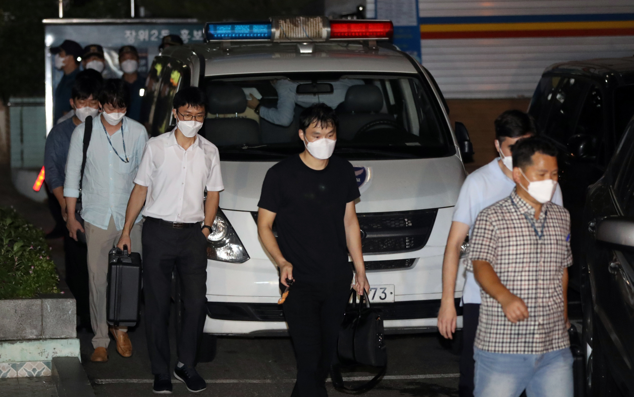 Police officers walk out of the Sarang Jeil Church in Seongbuk-gu, northern Seoul, after raiding the church building for more than four hours Friday night on charges of violating the infectious disease prevention law. (Yonhap)