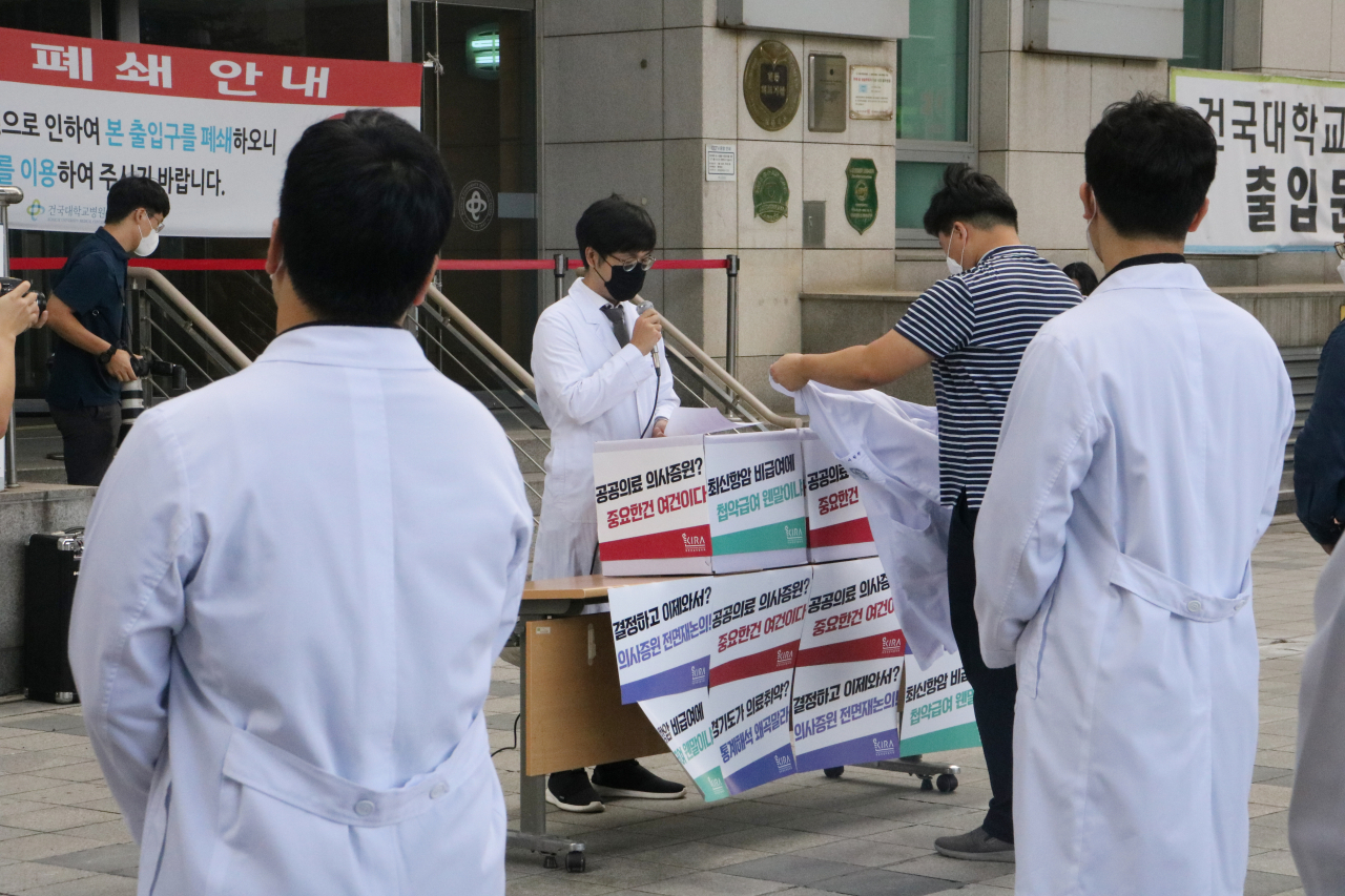 23일 서울 광진구 건국대병원에서 전공의들이 의대 정원 확대 재논의 등을 촉구하며 의사 가운을 벗고 있다. [연합]