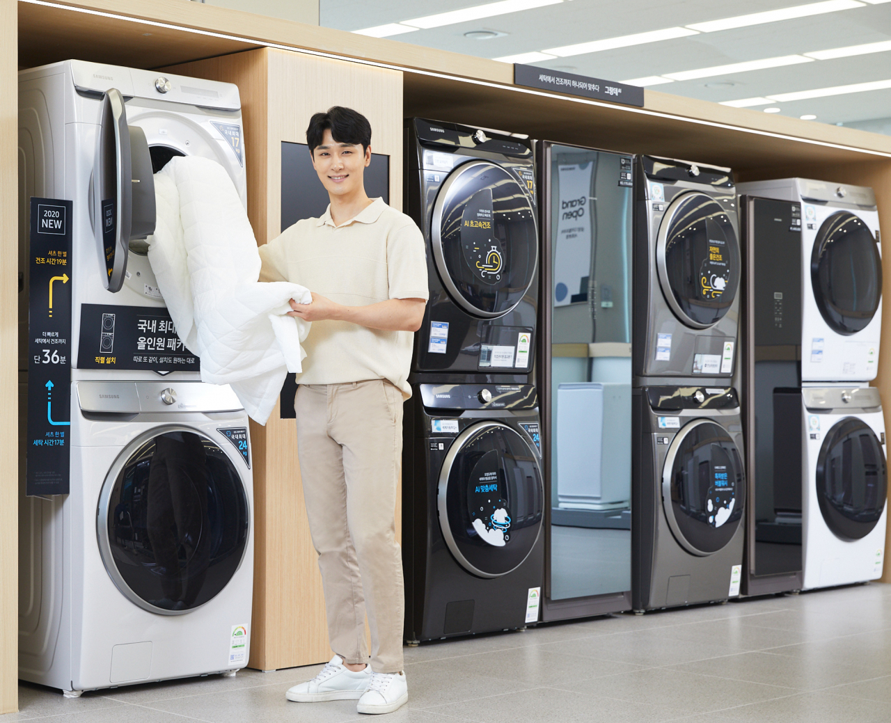 삼성전자 모델이 삼성디지털프라자 서초본점에서 국내 최대 용량의 '그랑데 AI' 17kg 건조기(위)와 24kg 세탁기(아래) 제품 패키지를 소개하고 있다. [삼성전자 제공]