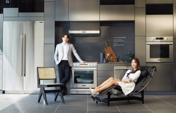 모델이 까시나의 대표 작품 중 하나인 LC4 라운지 체어(LC4 Lounge Chair)에 앉아 가전과 가구가 조화를 이루는 주방 공간을 소개하고 있다. [LG전자 제공]