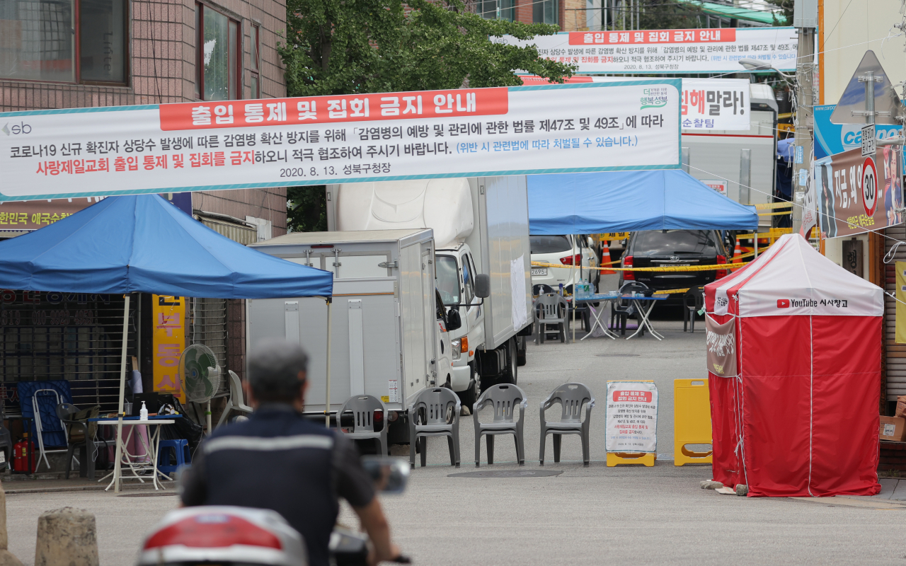 24일 오전 서울 성북구 사랑제일교회 앞에 한 시민이 지나가고 있다.[연합]