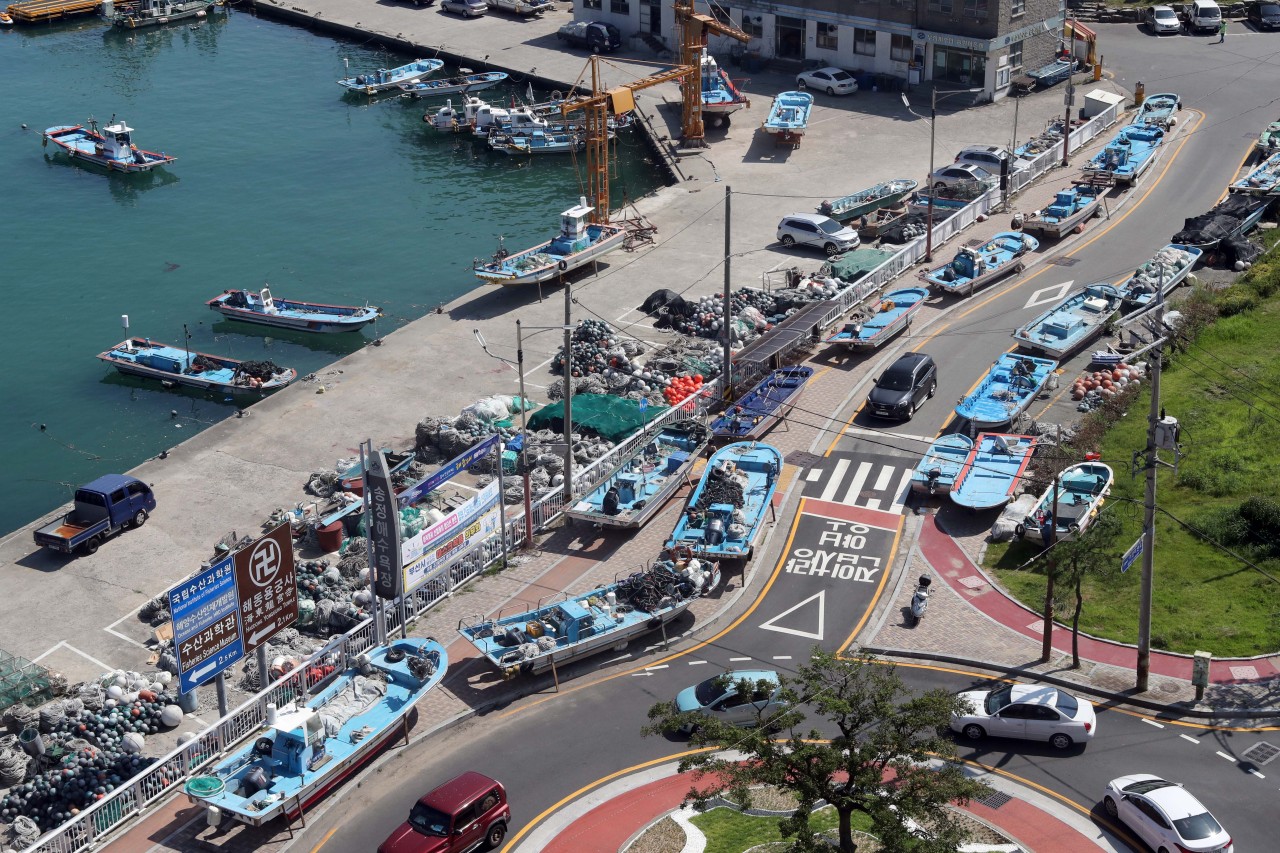 Fishing boats are parked on the ground Monday near a harbor in Busan, as authorities prepare for heavy winds and potential damage from the rise of typhoon Bavi, the eighth typhoon of the year. (Yonhap)