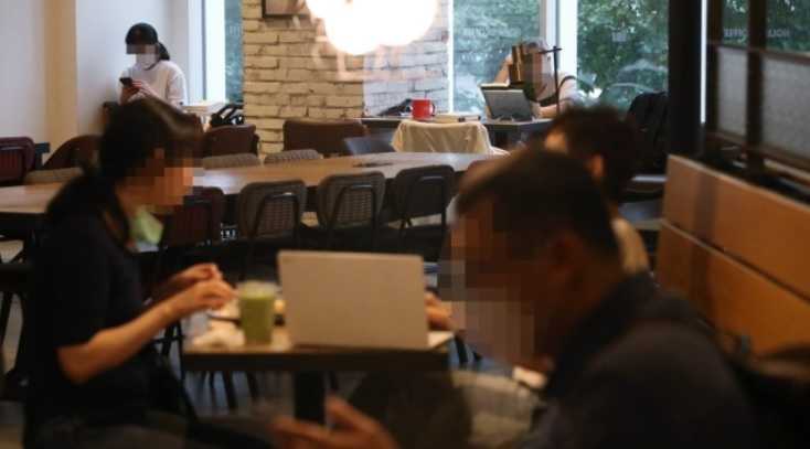 사회적 거리두기 2단계가 조치 중인 지난 21일 서울의 한 카페에서 마스크를 착용한 이용객과 착용하지 않은 이용객들이 각각 시간을 보내고 있다. [연합]