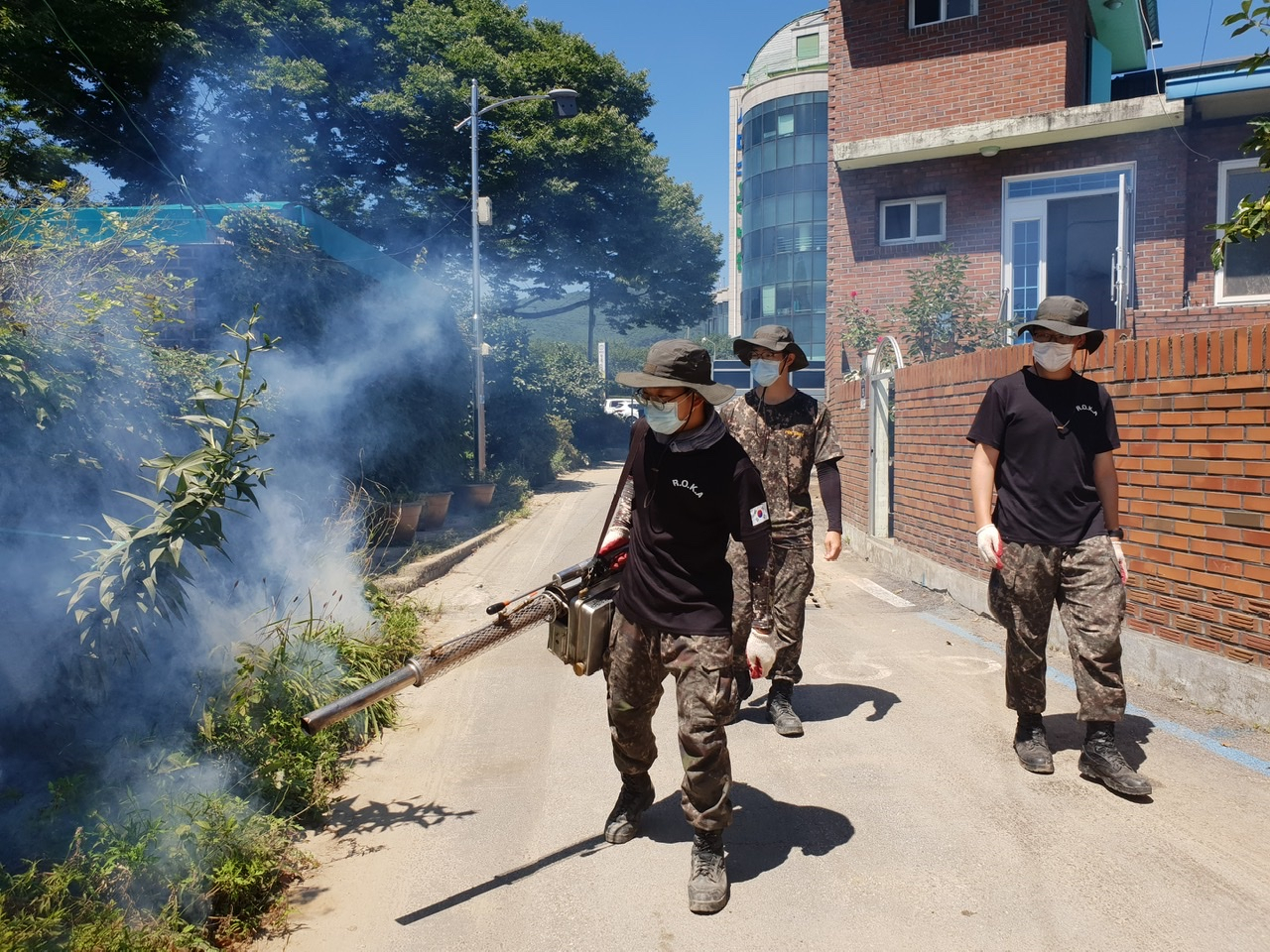 장병들이 마스크를 쓰고 수해 지역에서 방역 활동을 벌이고 있다.[연합]