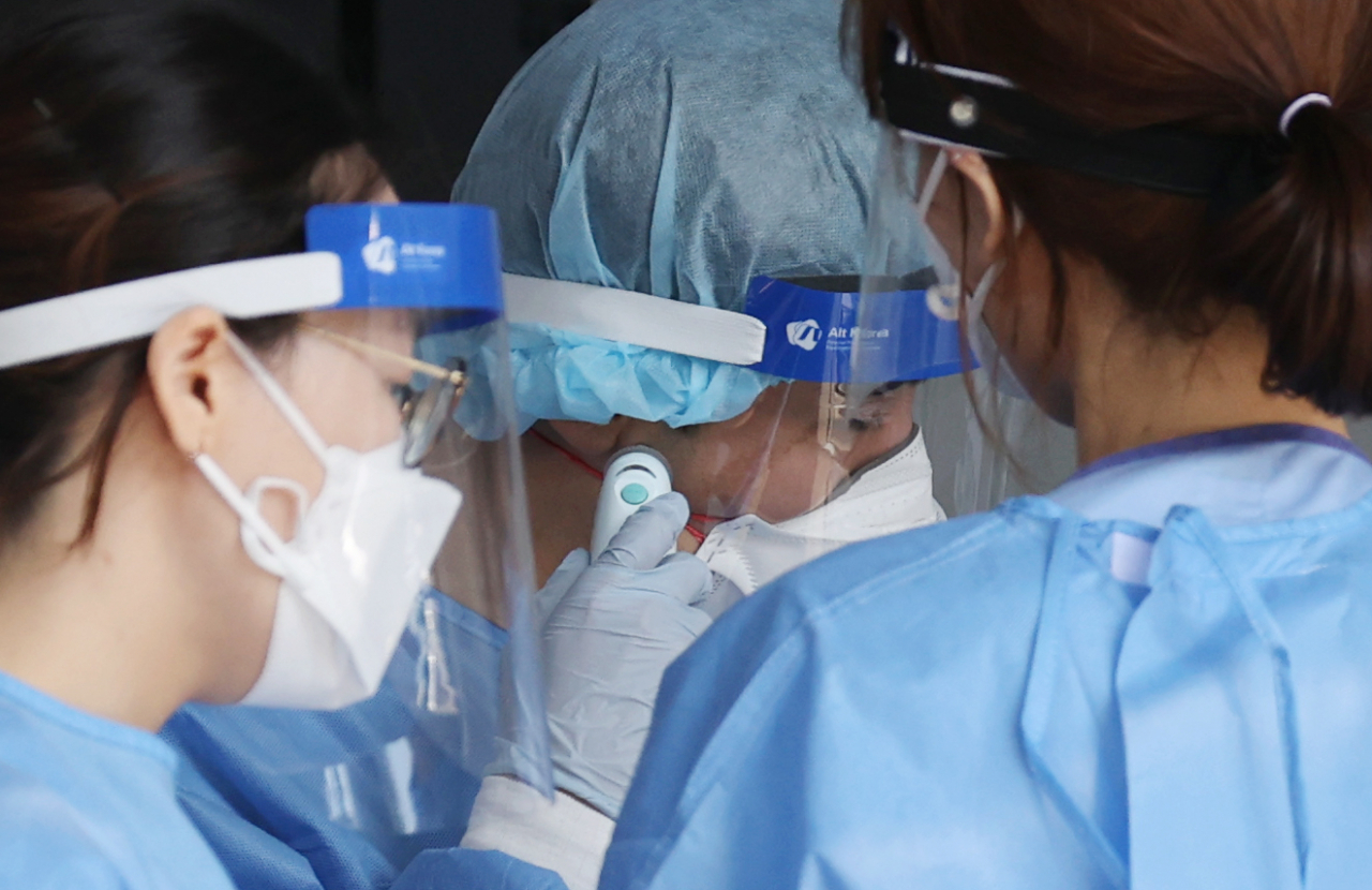 24일 서울 서대문구 세브란스병원 본관 앞에 마련된 안심진료소에서 의료진이 신종 코로나 바이러스 감염증(코로나19) 검사 관련 업무를 보던 중 체온계를 확인하고 있다. [연합]