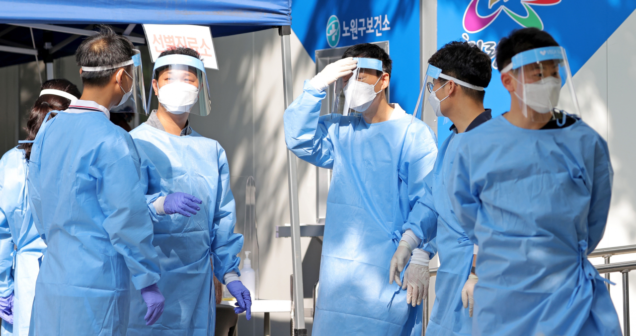 25일 오전 서울 노원구보건소 코로나19 선별진료소에서 의료진이 모여 이야기를 나누고 있다. [연합]