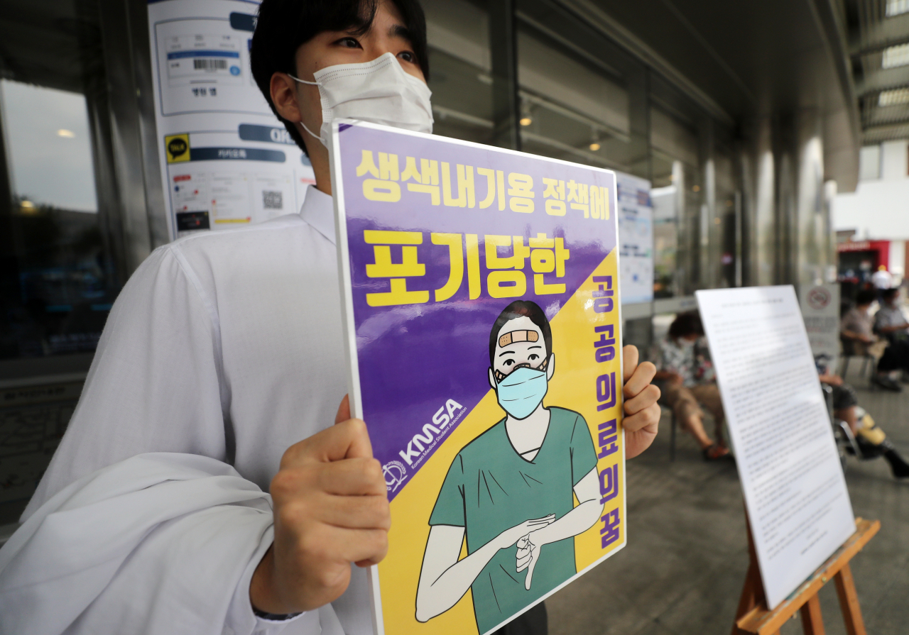 주요대학병원 전공의 파업을 하루 앞둔 20일 서울 종로구 서울대학병원 본관 앞에서 서울대 의대 3학년생이 의료계 현안 및 전공의 파업 지지 등의 내용이 담긴 성명문을 옆에 두고 릴레이 1인시위를 벌이고 있다. [연합]