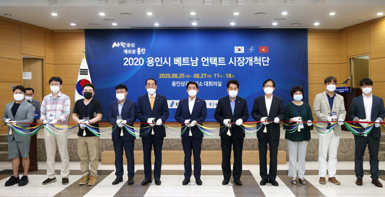 백군기 용인시장이 베트남 언택트 시장개척단 행사장에서 참석자들과 테이프 커팅을 하고 있다. [용인시 제공]