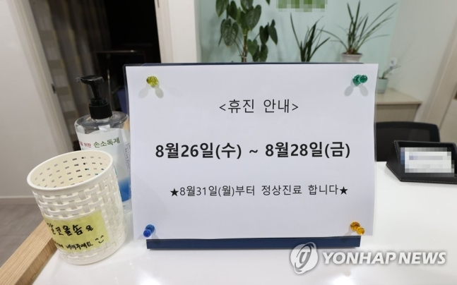 전국의사 2차 총파업을 하루 앞둔 25일 오후 서울 시내의 한 병원 출입문에 붙은 휴진 안내문[연합뉴스]