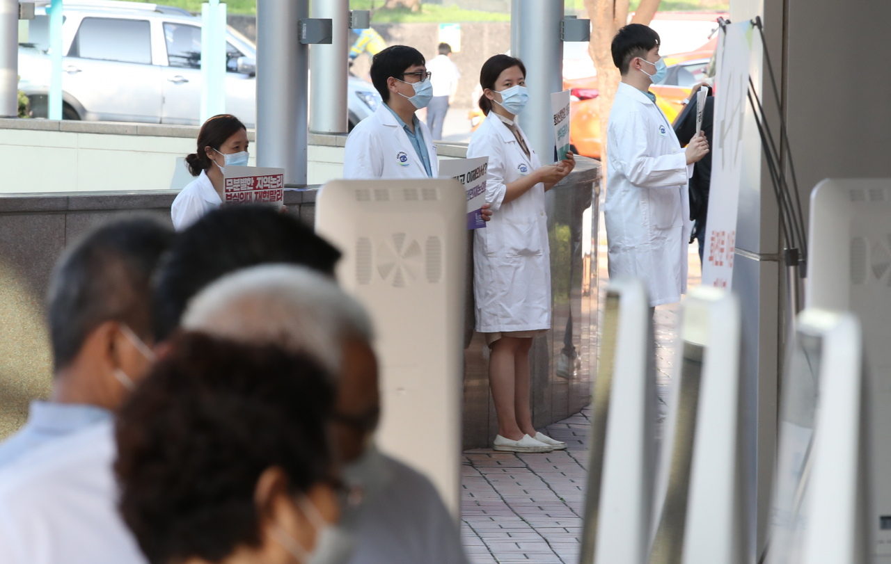 전국의사 2차 총파업 첫날인 26일 오전 서울 서초구 서울성모병원에서 전공의들이 피켓시위를 하고 있다. 정부는 이날 오전 8시를 기해 수도권 전공의·전임의에 업무개시명령을 발동했다. 연합뉴스