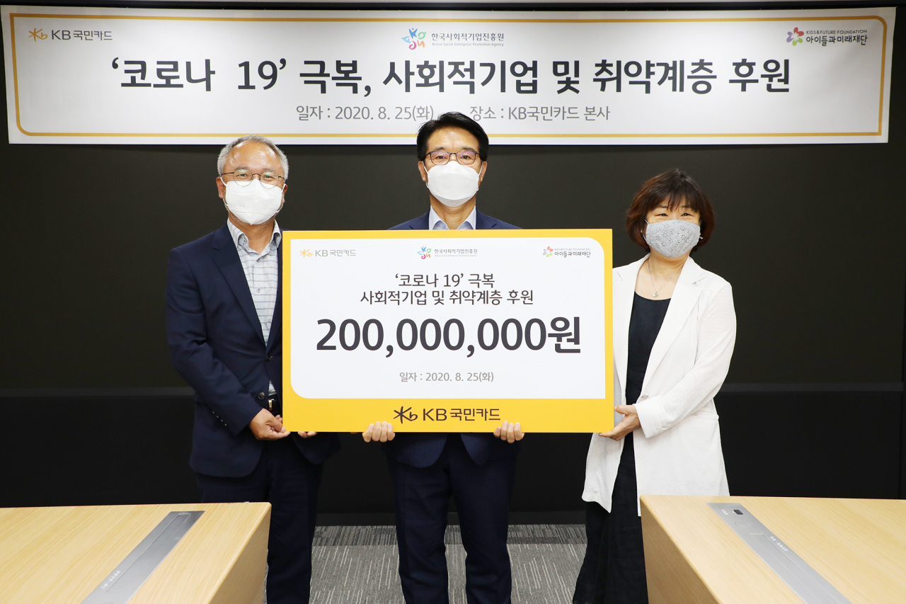 8월 25일 오후 서울 종로구 KB국민카드 본사에서 열린 '코로나19 극복을 위한 사회적 기업 및 취약 계층 후원식'에서 이동철 KB국민카드 사장(가운데)이 사회적 기업과 취약 계층 지원을 위한 후원금 2억원을 박두준 사회복지법인 '아이들과 미래재단' 상임이사(왼쪽)와 김인선 '한국사회적기업진흥원' 원장(오른쪽)에게 전달하고 있다.[사진=KB국민카드]