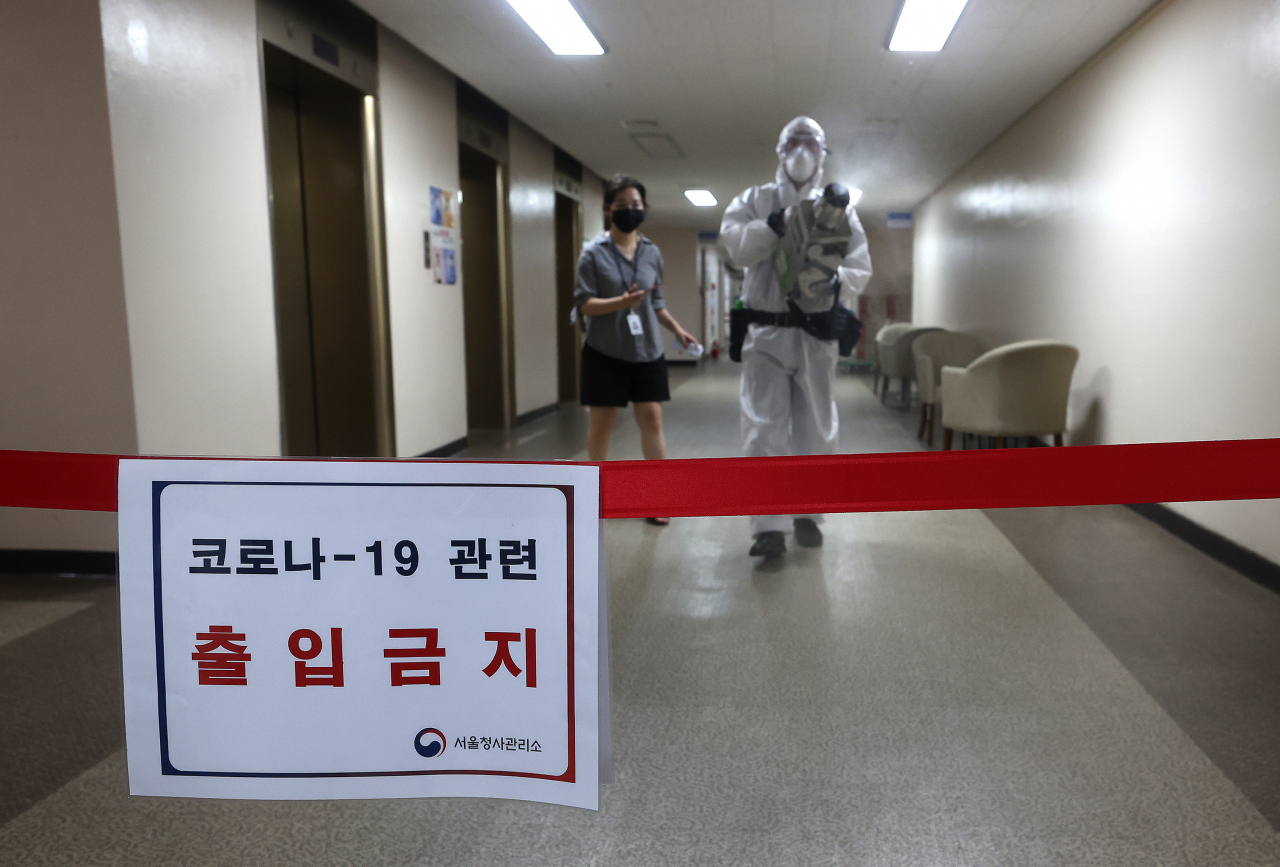 26일 오전 정부서울청사에서 코로나19 확진자가 발생해 방역 관계자가 소독을 하고 있다. 행정안전부 정부청사관리본부와 금융위원회에 따르면 청사에 근무하는 정부청사관리본부 소속 청원경찰 1명이 확진 판정을 받았다. [연합]