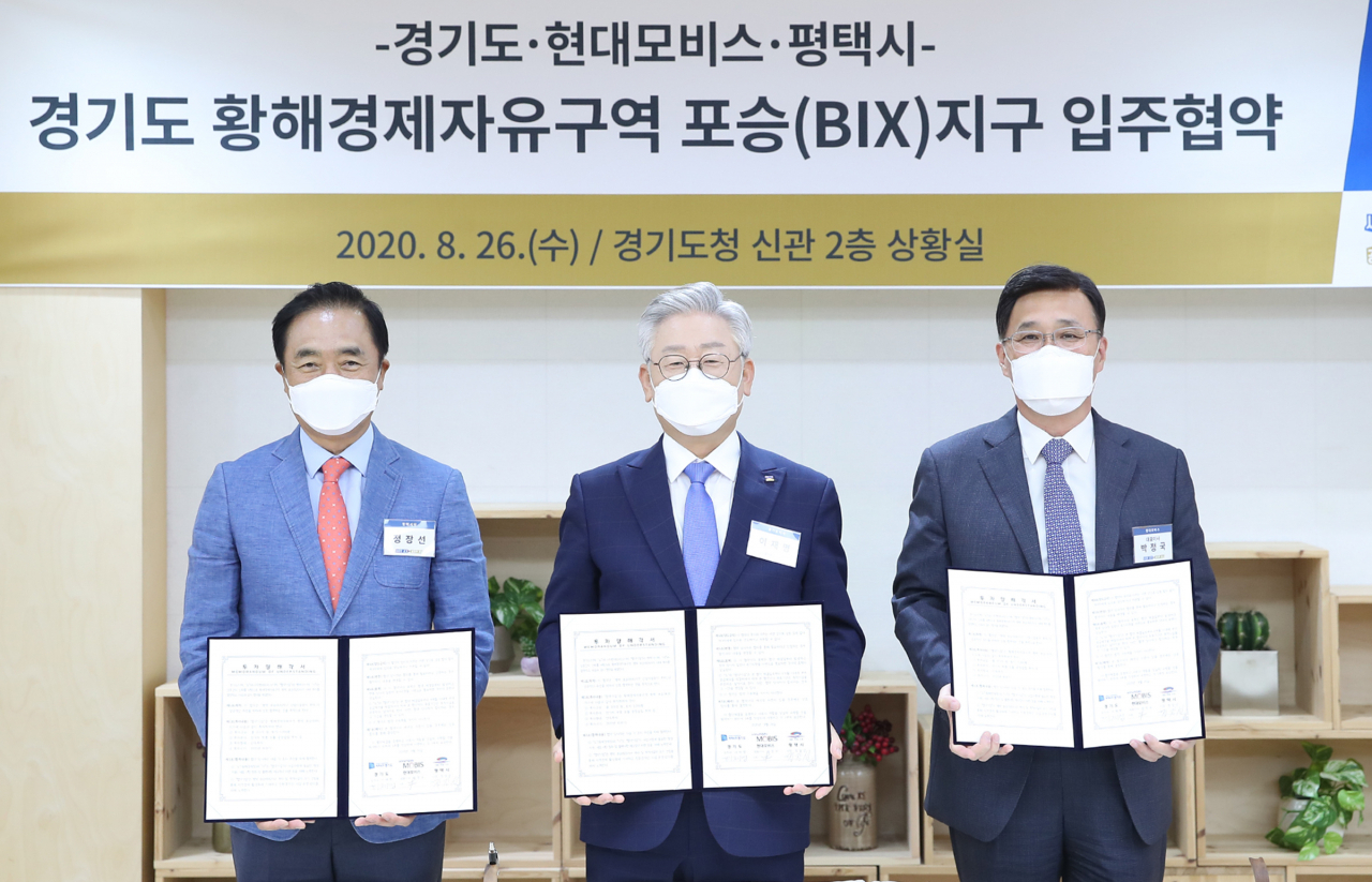 황해경제자유구역 평택 포승(BIX)지구 현대모비스 입주 협약식에서 이재명 경기도지사, 정장선 평택시장, 박정국 현대모비스 대표이사가 협약서에 서명을 하고 기념촬영을 하고 있다. [경기도 제공]