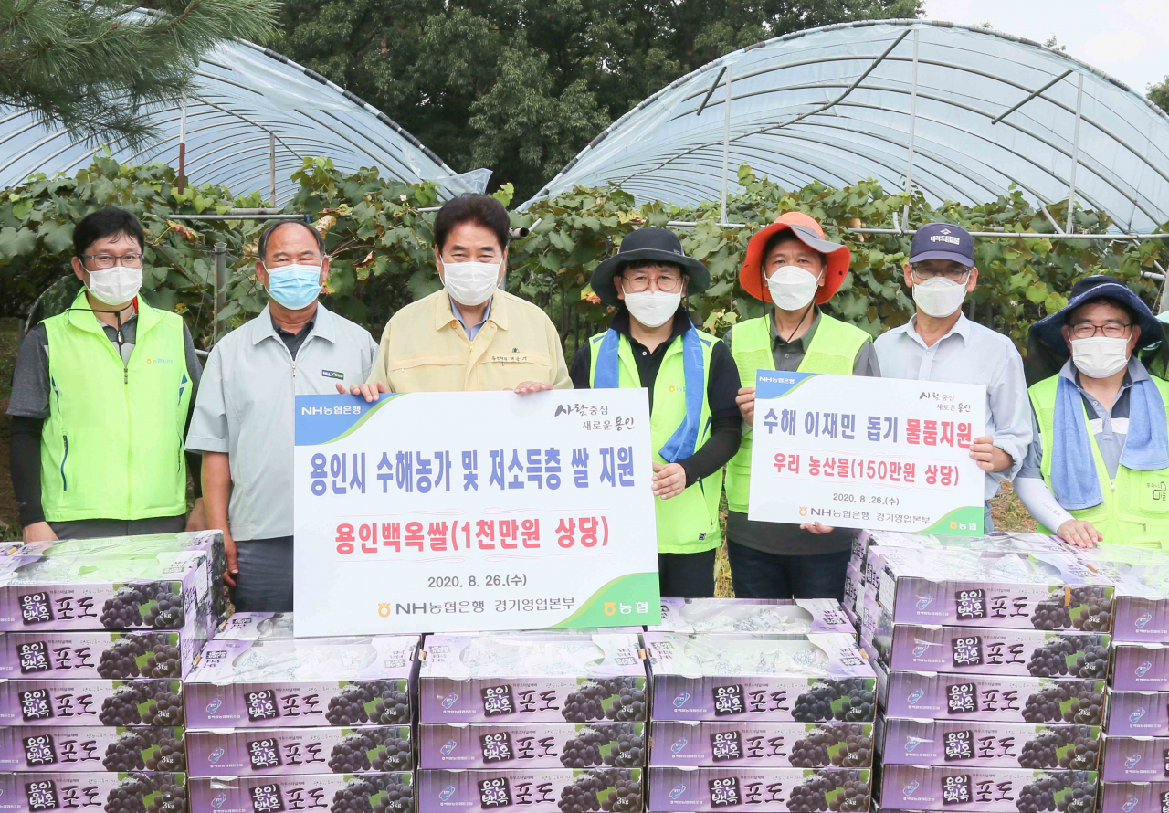 백군기 용인시장이 일손돕기 후 포도와 쌀을 기탁하는 NH농협 직원들과 기념사진을 찍고 있다. [용인시 제공]