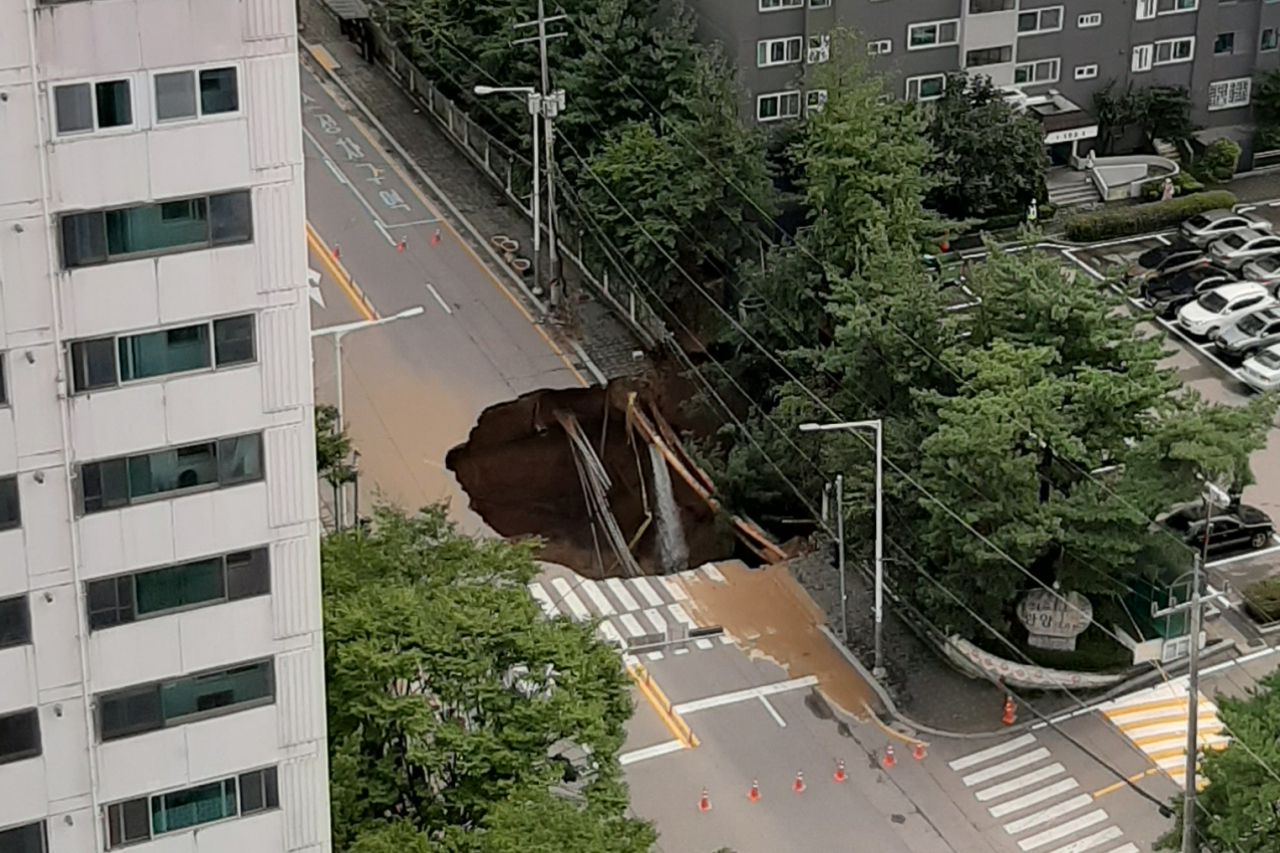 26일 오후 경기도 구리시 교문동의 한 아파트단지 앞 도로에 대형 싱크홀이 발생해 도로가 통제되어 있다. 현재까지 인명피해는 없는 것으로 파악됐다. [연합]
