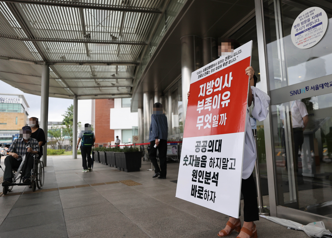 정부의 보건의료정책에 반대하는 대한의사협회의 집단휴진 이틀째인 27일 서울 종로구 서울대학교병원에서 전문의가 피켓 시위를 이어가고 있다. [연합]