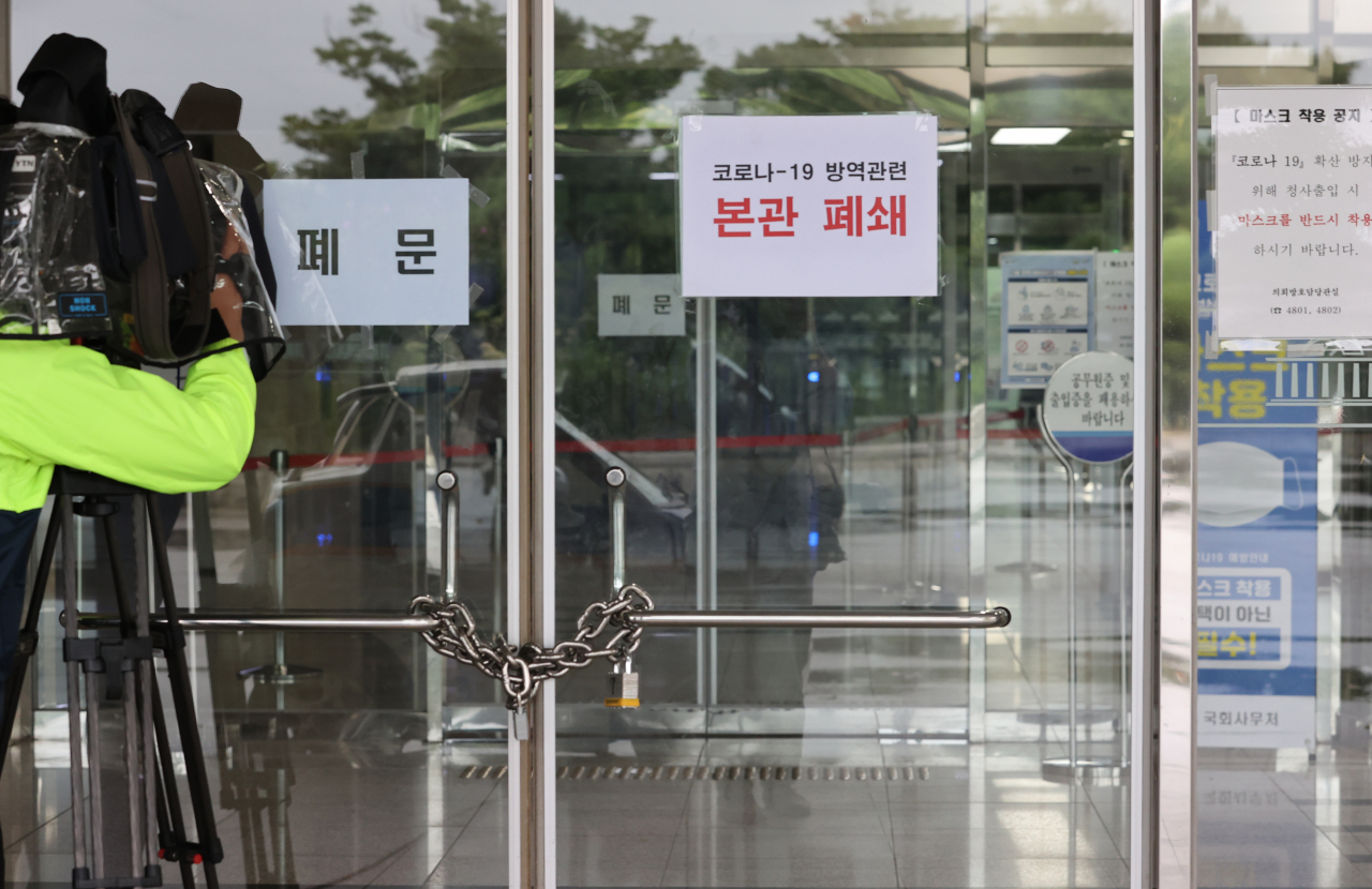 국회 출입기자의 신종 코로나바이러스 감염증(코로나19) 확진 판정으로 27일 오전 국회 본관이 폐쇄돼 출입구가 굳게 잠겨 있다. [연합]