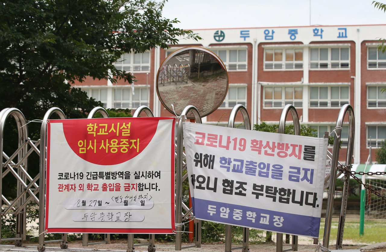 27일 오전 광주 북구 두암중학교 출입문이 굳게 닫혀있다. 이날 두암중학교 교사가 코로나19 확진 판정을 받으면서 교직원 40여명이 진단 검사를 받고 자가격리에 들어갔다. 온라인 학습 기간이어서 학생 접촉자는 없었다. 연합뉴스