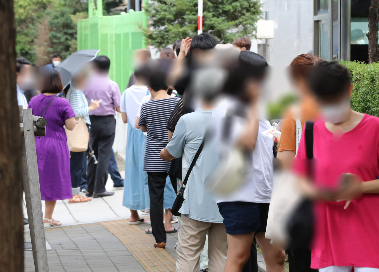 27일 오후 서울 노원구 보건소에 설치된 코로나19 선별진료소를 찾은 시민들이 검체 채취를 받기 전 대기하고 있다. [연합]