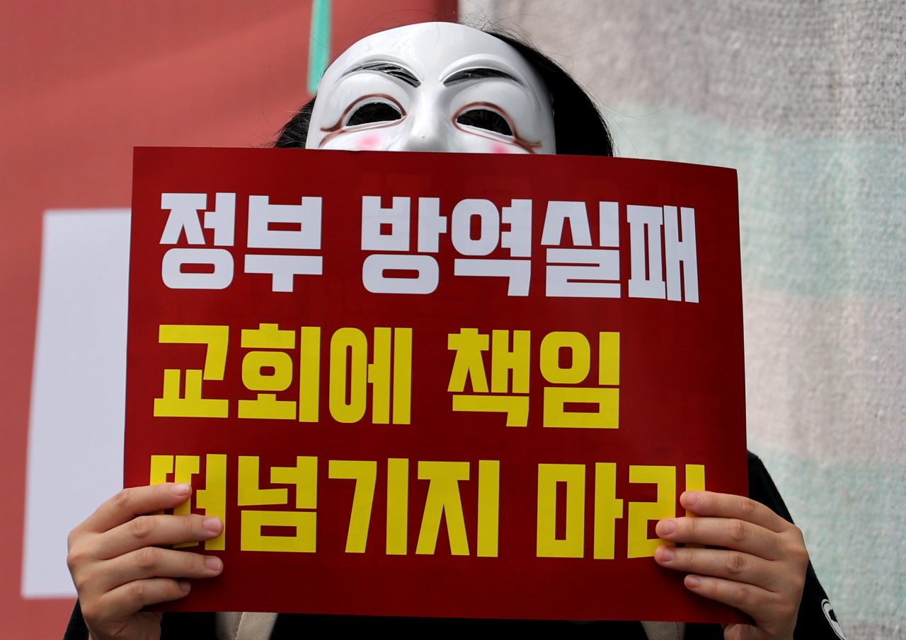 25일 오후 서울 성북구 사랑제일교회 앞에서 열린 정부 및 질병관리본부 규탄 기자회견에서 한 참가자가 손팻말을 들고 있다. [연합]