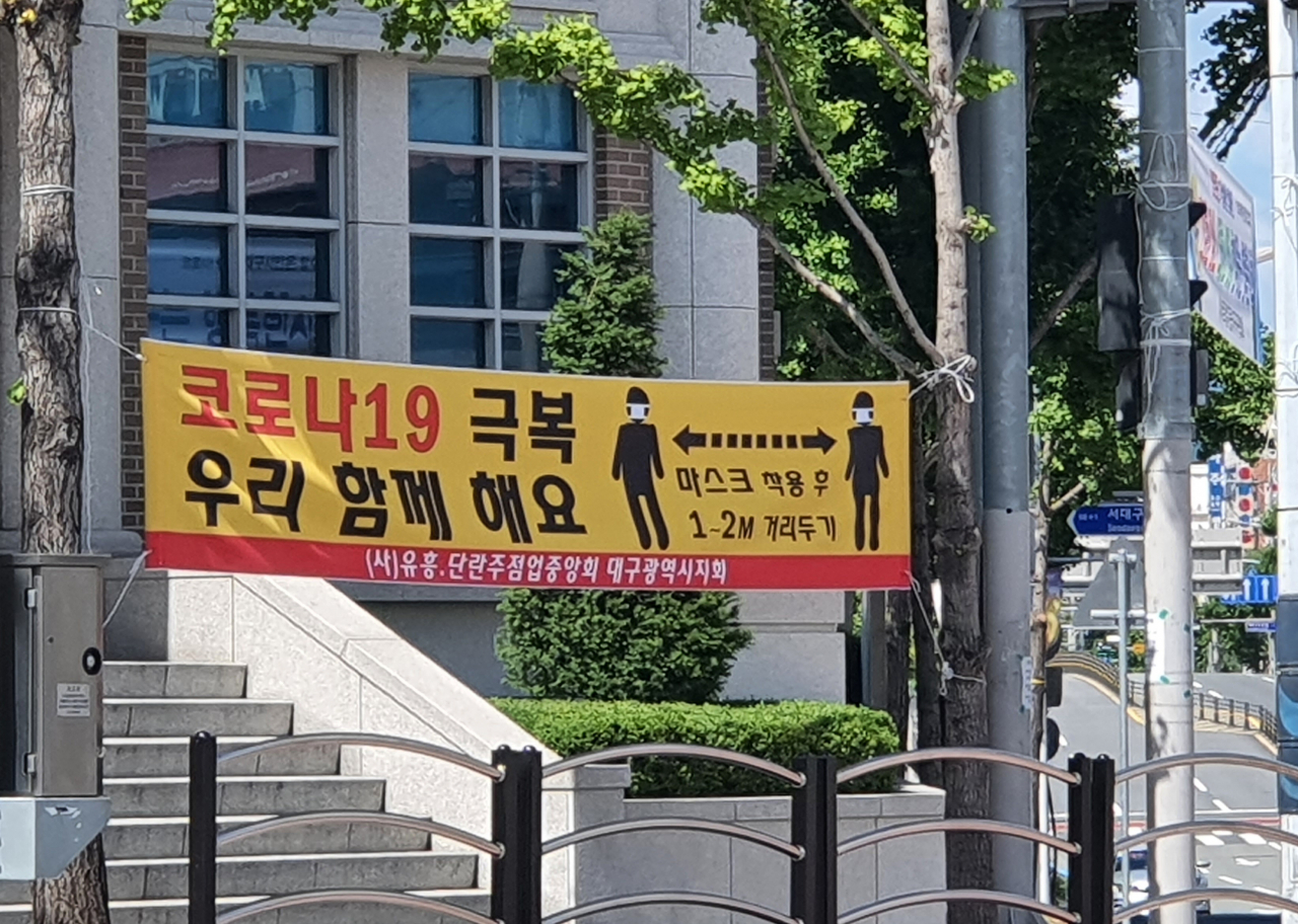 30일 대구 서구 신평리네거리에 사단법인 유흥·단란주점업중앙회 대구광역시지회가 설치한 사회적 거리두기 현수막이 걸려있다. [연합뉴스]