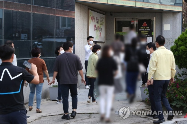 30일 오전 광주 서구 한 개신교회 입구에서 현장 점검에 나선 공무원이 대면 예배에 참석하는 신도들에게 집합금지 행정명령 준수를 당부하고 있는 모습 [연합뉴스]