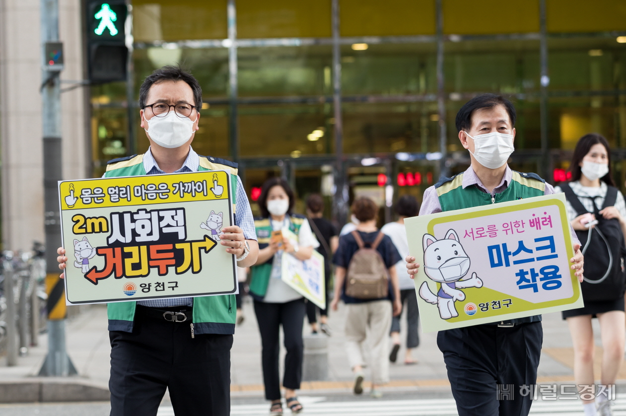 지난 25일 목동동로 축제의 광장 거리에서 양천구청 공무원들이 코로나19 방역을 위한 사회적 거리두기 동참을 독려하는 캠페인을 벌이고 있다. [양천구 제공]