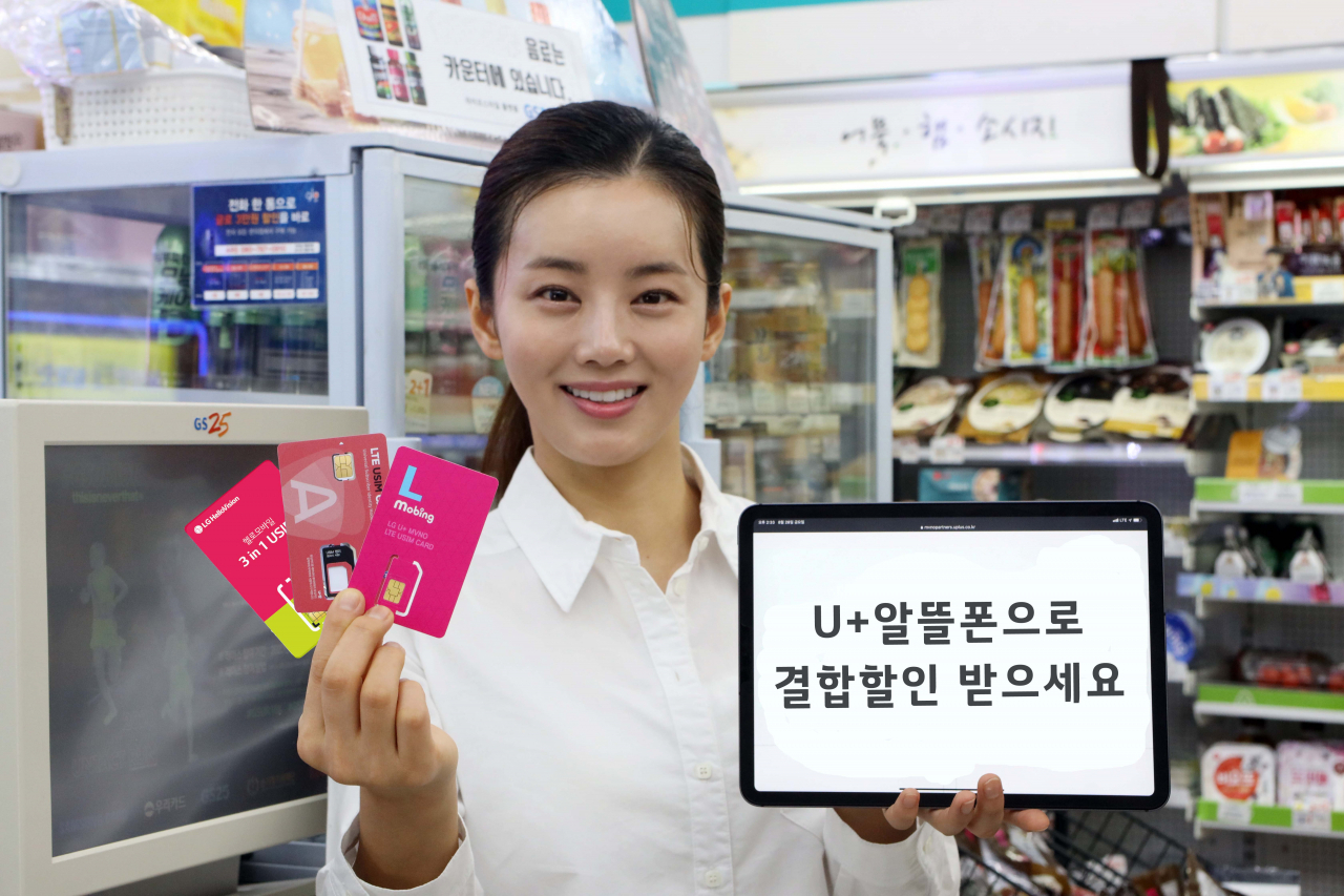LG유플러스는 ‘참 쉬운 가족결합’을 다음 달 1일부터 ‘U+알뜰폰’ 고객에게까지 확대한다고 31일 밝혔다. 사진은 모델이 유심 카드를 들고 U+알뜰폰 요금제를 소개하고 있는 모습. [LG유플러스 제공]