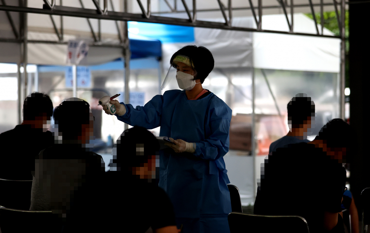 국내 신종코로나바이러스 감염증(코로나19) 신규 확진자가 248명 발생한 31일 오전 서울 성동구보건소에 마련된 선별진료소에서 의료진이 발열 검사를 하고 있다. 연합뉴스