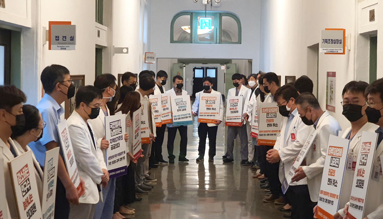 31일 보건복지부의 전공의 근무실태 파악에 반발해 경북대병원 의과대학 교수들이 손팻말을 들고 시위하고 있다. [연합]