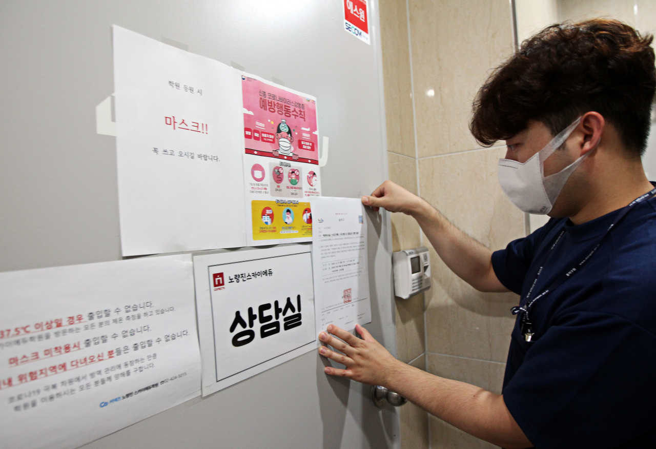 수도권 강화된 사회적 거리두기 2단계 시행에 따라 노량진 소재 학원에 집합금지명령서를 부착하고 있다. [동작구 제공]