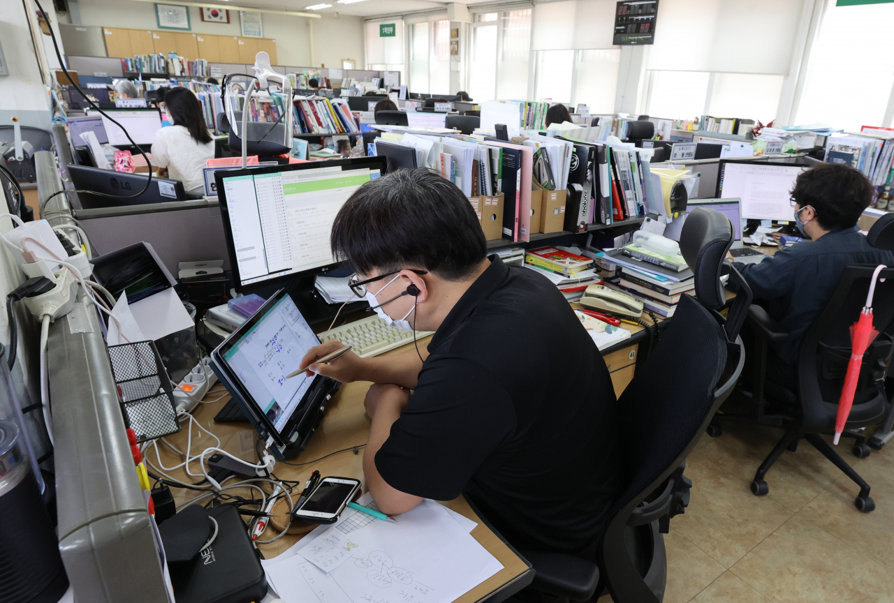 신종 코로나바이러스 감염증(코로나19) 재확산에 서울·경기·인천 소재 유·초·중·고교와 특수학교가 전면 원격 수업에 들어간 지난 달 26일 오후 서울 송파구 보인고등학교 교무실에서 선생님들이 원격으로 수업을 하고 있다. [연합]