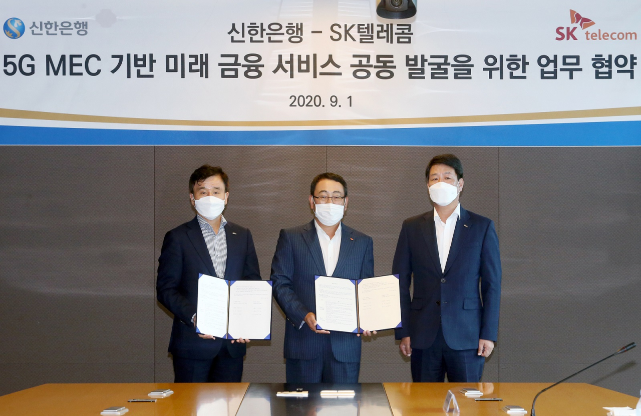신한은행은 1일 서울 중구 을지로에 위치한 SK텔레콤 본사에서 ‘신한은행-SK텔레콤 5G MEC 기반미래 금융 서비스 공동 발굴을 위한 업무 협약식’을 진행했다. 신한은행 박우혁 부행장, 유영상 MNO사업대표, 신한은행 이명구 부행장(맨 왼쪽부터)이 기념 사진을 촬영하는 모습.
