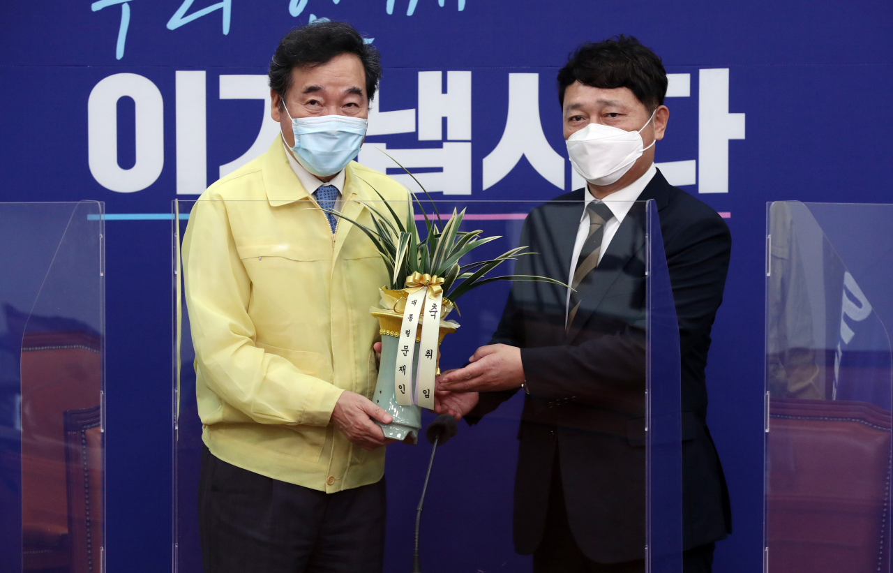 이낙연 더불어민주당 대표가 2일 서울 여의도 국회 더불어민주당 당대표실에서 최재성 청와대 정무수석의 예방을 받고 문재인 대통령의 취임 축하 난을 전달받고 있다. [연합]