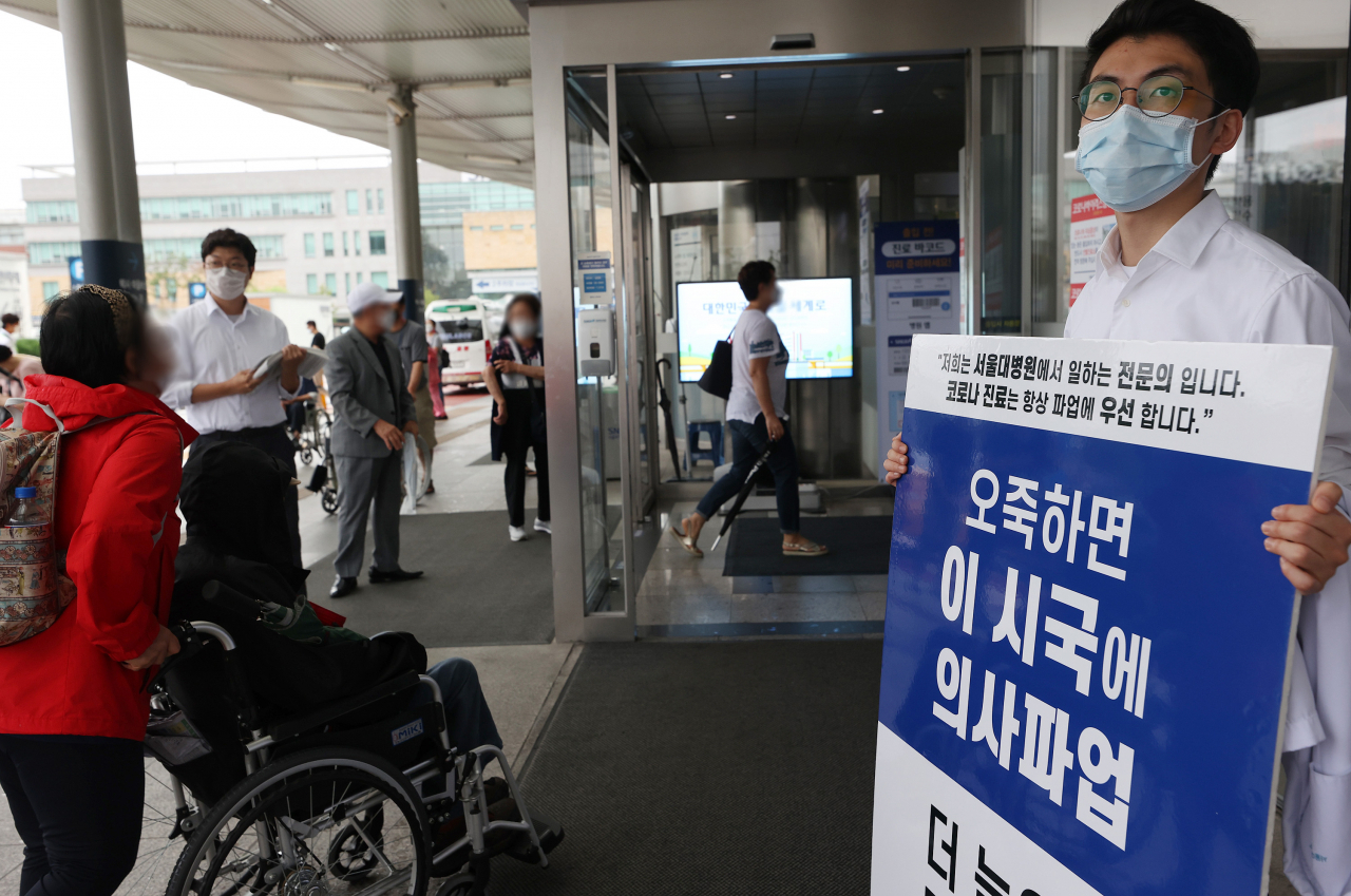 정부의 보건의료 정책에 반대하는 의료계가 집단휴진 중인 2일 오전 서울 종로구 서울대병원 본관 앞에서 전공의와 전문의가 정부의 보건정책에 반대하는 1인 시위를 하며 홍보물을 나눠주고 있다. [연합]