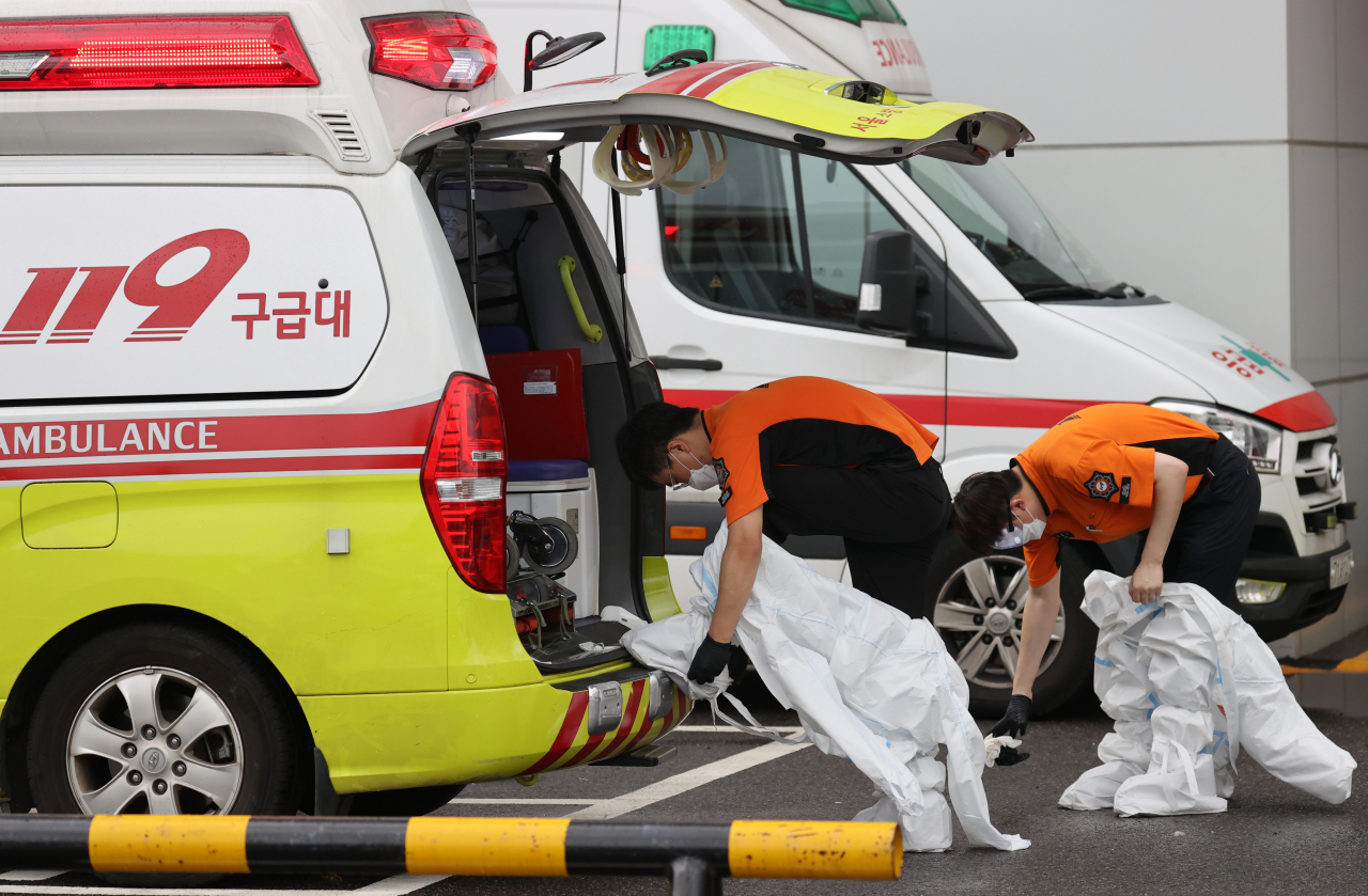 정부의 보건의료정책에 반대하는 대한의사협회의 집단휴진 이틀째인 27일 서울 종로구 서울대학교병원 응급의료센터 앞에서 119구급대원들이 환자 이송을 마친 뒤 레벨D 방호복을 탈의하고 있다. 연합뉴스