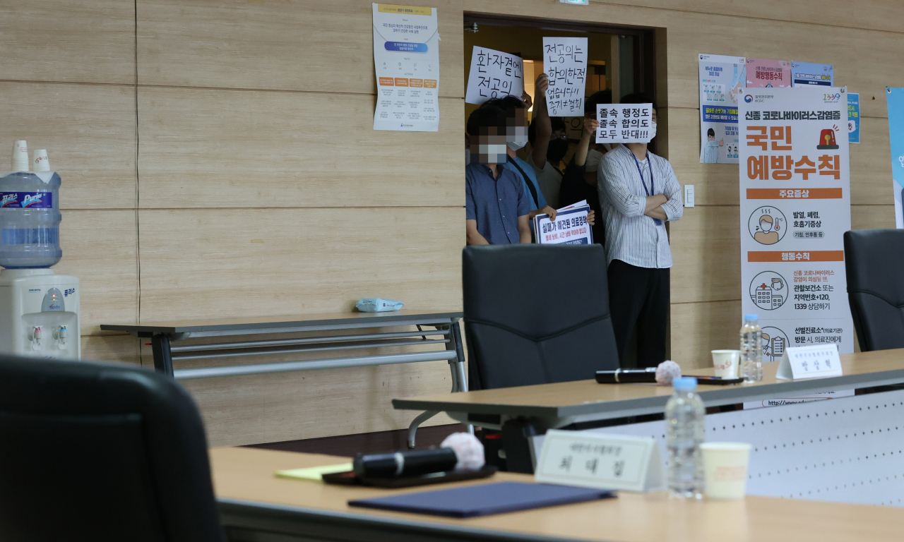 4일 오후 서울 회현동 건강증진개발원에서 열릴 예정인 의·정 협의체 구성 합의서 서명식장 앞에서 전공의들이 '졸속 합의 반대'를 주장하며 시위를 벌이고 있다. 연합뉴스