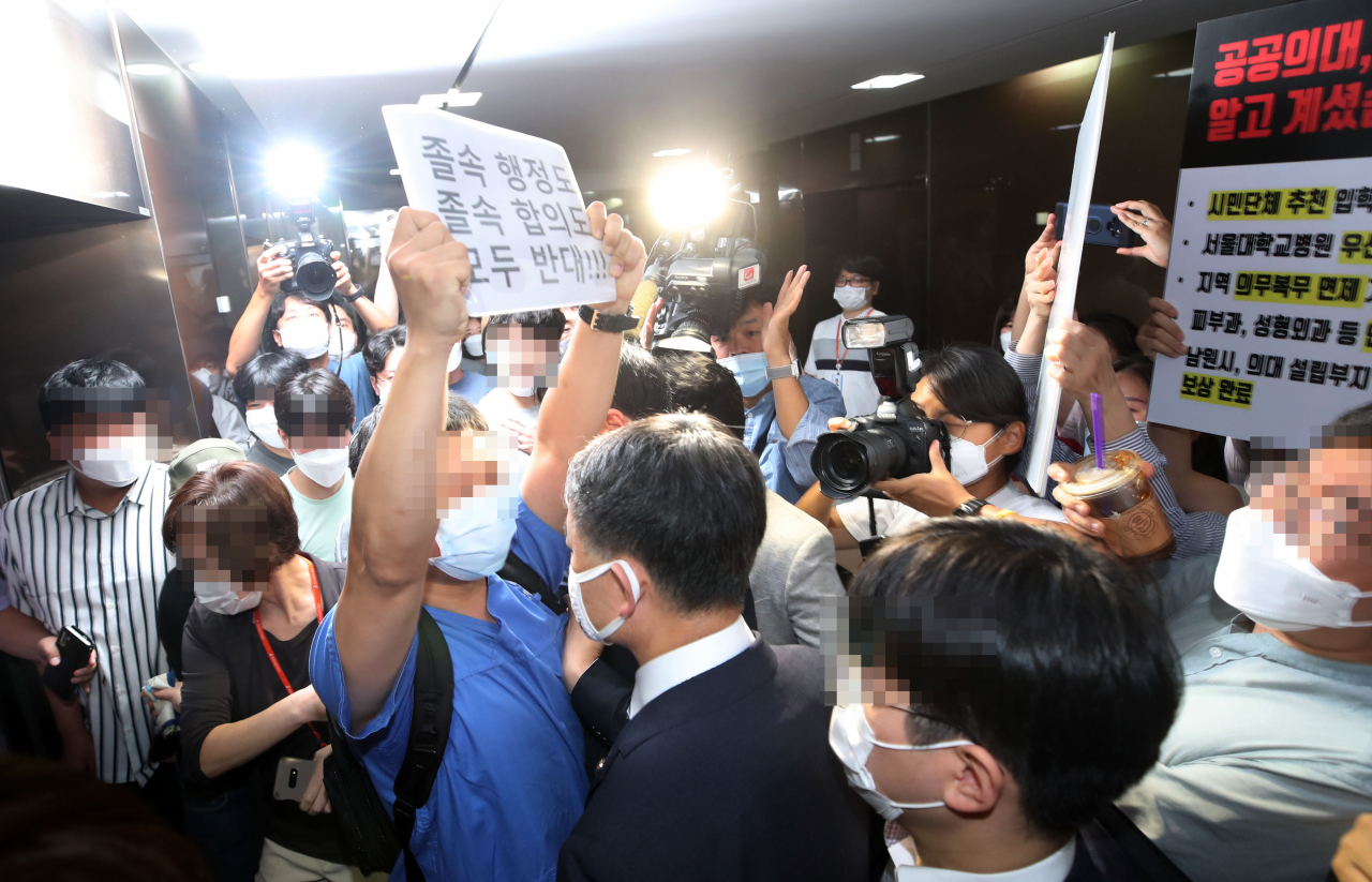 박능후 보건복지부 장관이 4일 오후 서울 회현동 한국건강증진개발원에서 열린 최대집 의사협회장과의 합의 서명식을 위해 식장으로 향하자 전공의들이 저지하고 있다. [연합]