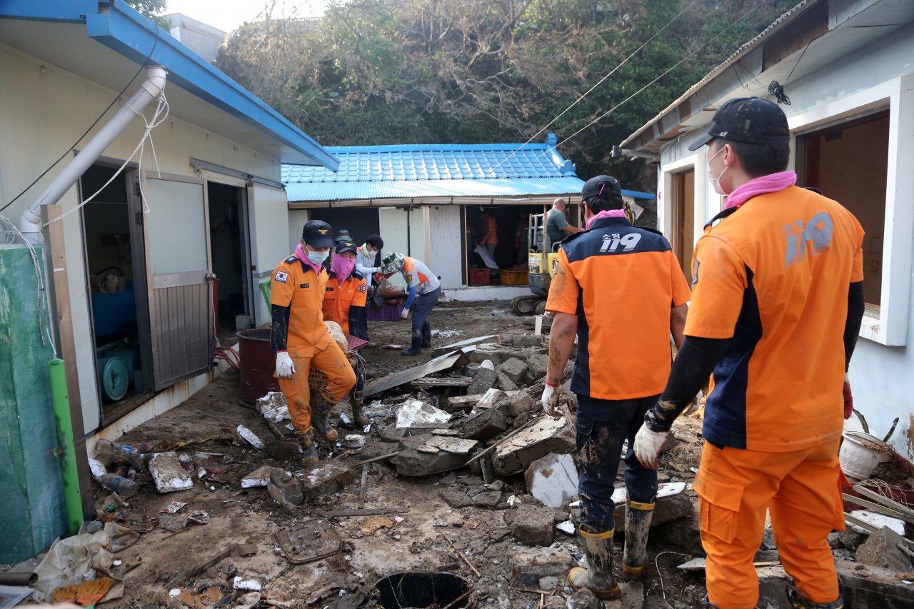 4일 경북 경주시 감포읍 감포항 옆 친수공간이 지난 3일 한반도를 휩쓸고 간 태풍 '마이삭' 영향으로 대형 파도가 몰아치면서 쑥대밭이 됐다. 소방대원과 의용소방대원 등이 침수된 주택에서 쓰레기를 치우고 있다. [연합]