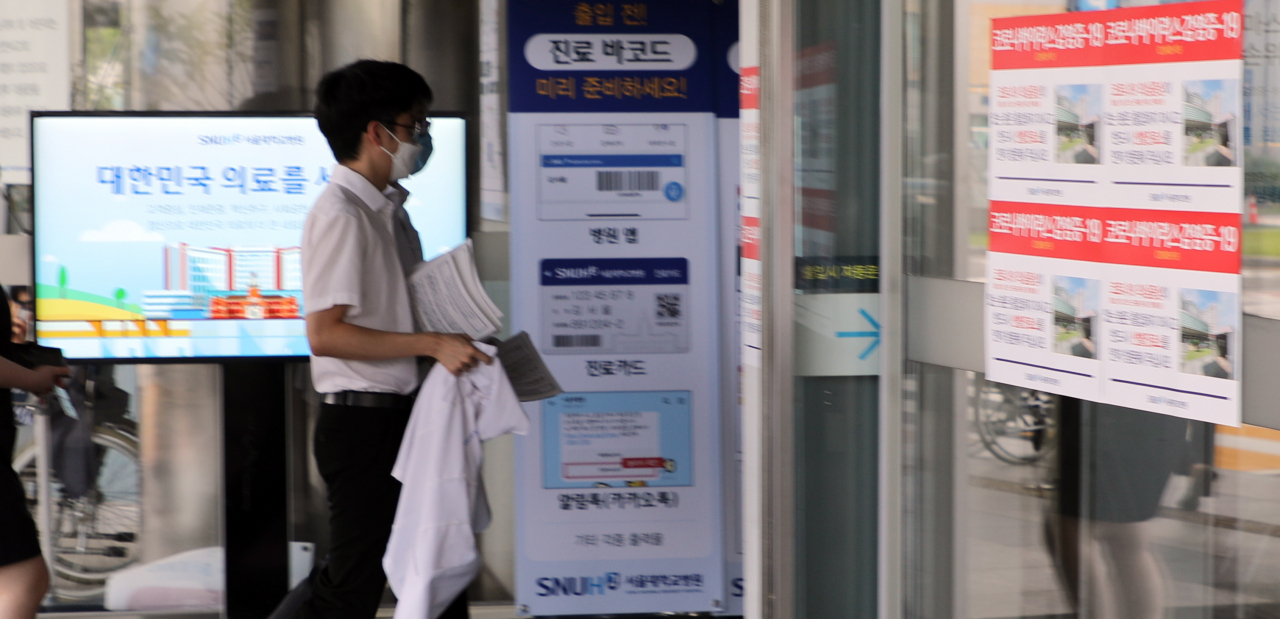 대한의사협회가 더불어민주당과 공공의료 확충 정책 입법을 재검토하기로 최종 합의한 4일 오전 서울대학교병원에서 보건의료 정책에 반대하며 일인시위를 하던 의사들이 병원 안으로 들어가고 있다. [연합]
