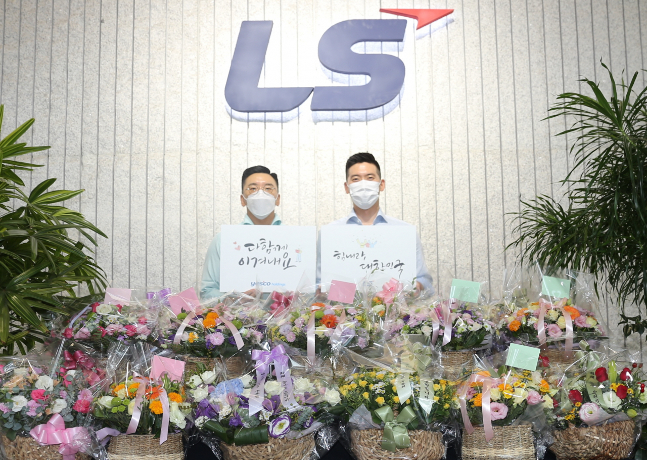 구본혁 예스코홀딩스 부사장(좌)과 구동휘 (주)LS 전무(우)가 7일, '플라워 버킷 챌린지'에 동참하고 '다함께 이겨내요', '힘내라 대한민국' 응원 메세지를 전달하고 있다. [LS그룹 제공]