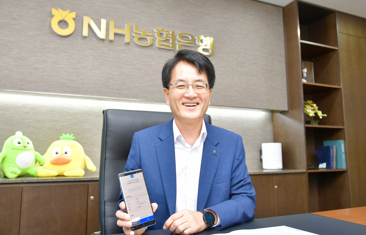 7일 서울시 중구 NH농협은행 본점에서 손병환 은행장이 스마트뱅킹을 통해 직접 NH운전자상해보험을 가입하고 있다. [사진=NH농협은행]