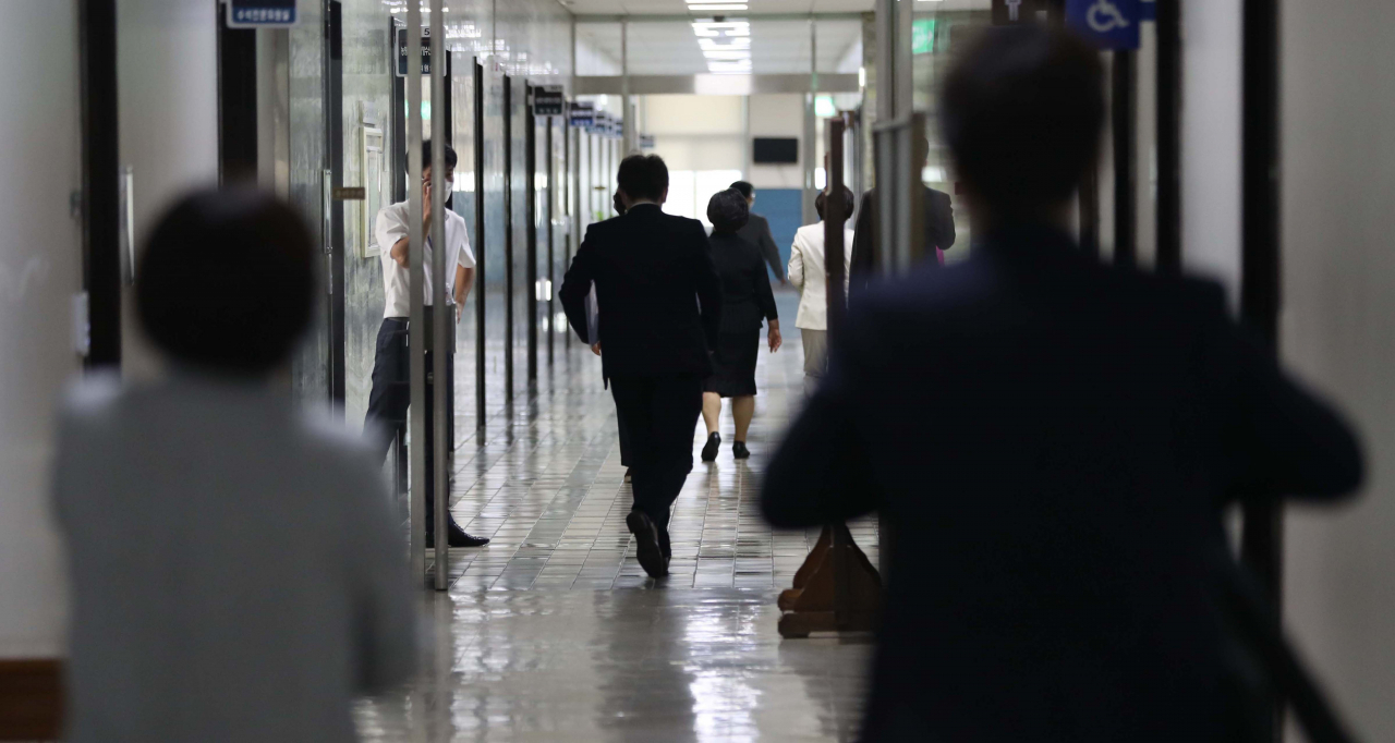 7일 오전 국회 출입기자 1명이 코로나19 추가 확진 판정을 받자 국회 본청 4층 직원들이 긴급 방역 등을 위해 사무실을 나서고 있다. [연합]